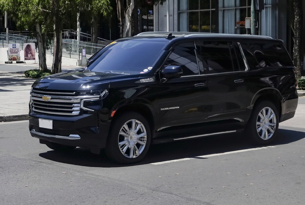 Black Chevrolet Suburban High Country three-quarter view on a city street